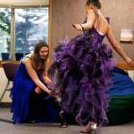 IzSabella Haviland, 17, slips a shoe, Cinderella-style, on her friend Tetyana Popach, 17, while trying on formal wear to wear Friday night to their school&rsquo;s first-ever prom. (Dan Bates / The Herald)