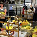 Volunteers unload bags of nonperishable food donated during the 2016 Letter Carriers Food Drive. Scheduled for May 13, the effort to help local food banks feed hungry people in Snohomish County will mark its 25th anniversary this year. (Volunteers of America Western Washington photo)