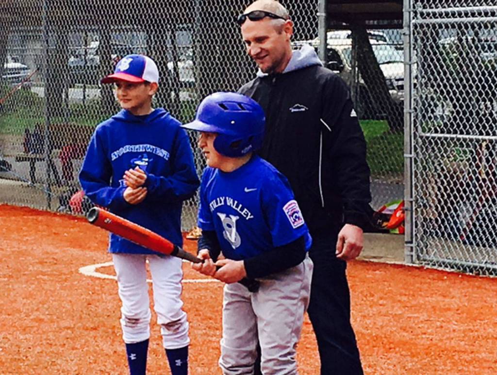 Jacob Irish contemplates a turn at bat. He is helped by his father, Steve Irish, and brother Noah, 11, at a recent game with the Stilly Valley Little League Challenger Division. The Challenger program gives kids with special needs a chance to play baseball. (Melanie Irish photo)
