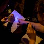 Catherine Harlow (left) and Alicia Flansburg use blacklights to find hidden messages on documents at the new Escape Scene in downtown Everett on May 6. (Ian Terry / The Herald)