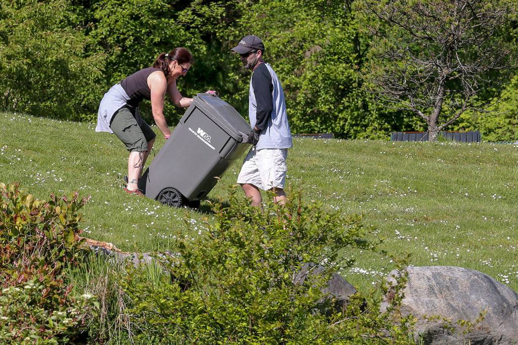 Adina Duke, left, and Rob Bolen work to haul yard waste from Little Cedars Elementary Saturday morning during the 3rd annual Day of Hope in Snohomish on May 20, 2017. Sponsored by Gold Creek Community Church, the two-day event drew nearly 1300 volunteers. (Kevin Clark / The Herald)