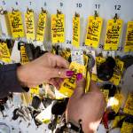 Volunteer Toni Oswalt hangs keys in the parking lot of Kaman Auctions in Edmonds. (Ian Terry / The Herald)