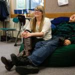 McKayla Olson, 18, and her longtime boyfriend, Andrew Anthony, 20, enjoy watching the prom dress fashion show as classmates come by to try on formal wear Thursday. (Dan Bates / The Herald)