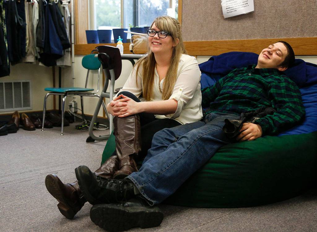 McKayla Olson, 18, and her longtime boyfriend, Andrew Anthony, 20, enjoy watching the prom dress fashion show as classmates come by to try on formal wear Thursday. (Dan Bates / The Herald)