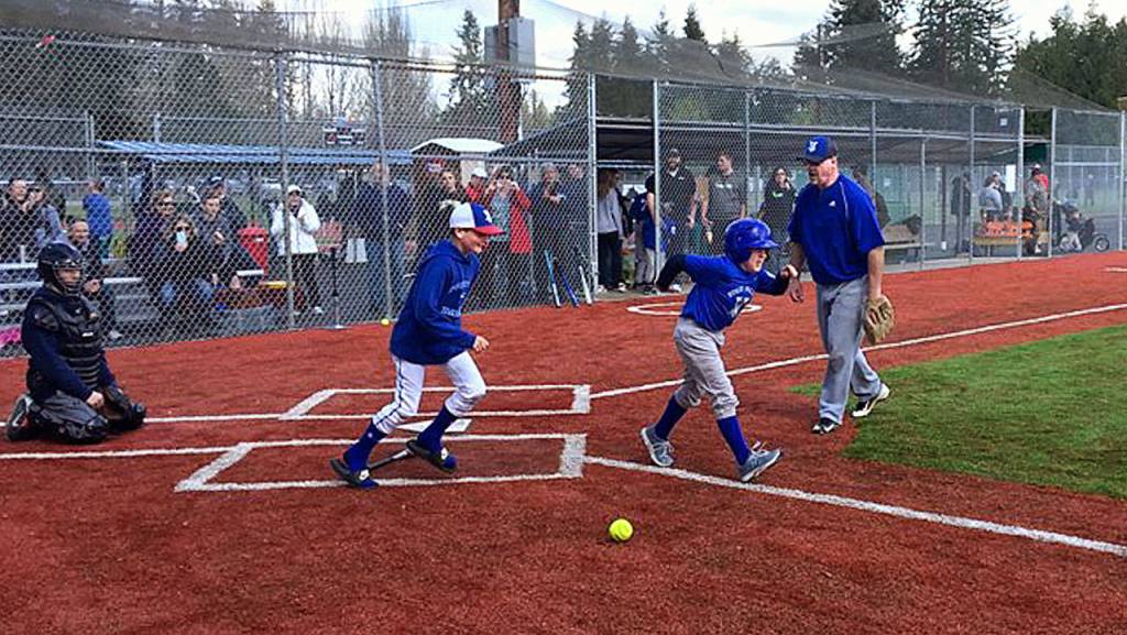 Jacob takes off up the first base line with his brother, Noah, following close behind after making a hit while playing some ball with the Stilly Softball girls team. (Courtesy Stilly Valley Little League)