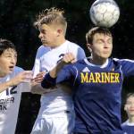 Mariner&rsquo;s Edward Katynskiy heads the ball with Glacier Peak&rsquo;s Camron Miller (left) and Glacier Peak&rsquo;s Kevin Ramsey challenging at Lake Stevens High School on May 11. (Kevin Clark / The Herald)