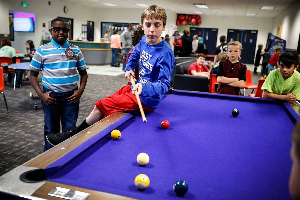 Cory Middleton, 11, lines up a shot at the Arlington Boys and Girls Club on May 16. (Ian Terry / The Herald)