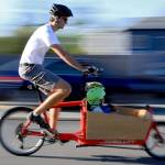 Tyler Rourke rides the Bullitt last summer, a cargo bike designed to carry his two sons. (Kevin Clark / Herald file)