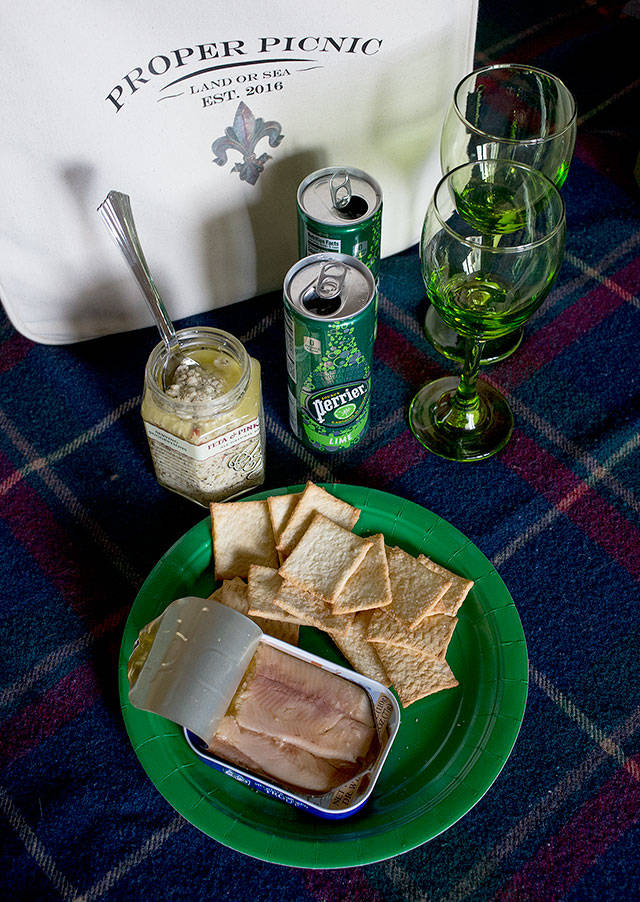 A tin of trout is paired with lemon crackers, a feta and pink peppercorn spread and lime Perrier, part of a picnic basket from Kelly Colman, owner of Proper Picnic. The company sells all you&rsquo;ll need to have a proper picnic. (Andy Bronson / The Herald)