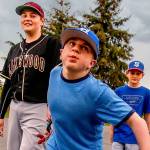 Brothers Matthew Irish, 15 (left), and Noah, 11, follow their older brother, Jacob, 16, as they walk to their car from the baseball field at Lakewood Middle School on Thursday after games were canceled by lightning. Jacob, who was born with life-threatening Hurler syndrome, is playing on a baseball team for the first time. (Dan Bates / The Herald)