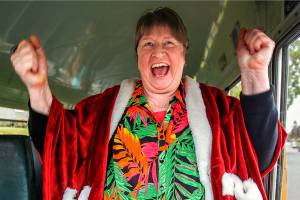 A delighted Sue Cheffer climbs into the driver&rsquo;s seat of a vintage Crown Motor Coach school bus when fellow drivers at Everett School District&rsquo;s bus barn at 37th and Oakes surprised her with a party and a ride Wednesday, just two days before her retirement. (Dan Bates / The Herald)