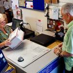 At the Silvana Post Office on Thursday morning, SSA clerk Debbie Nield helps Dwaine Howe, of Camano Island, mail a package. (Dan Bates / The Herald)