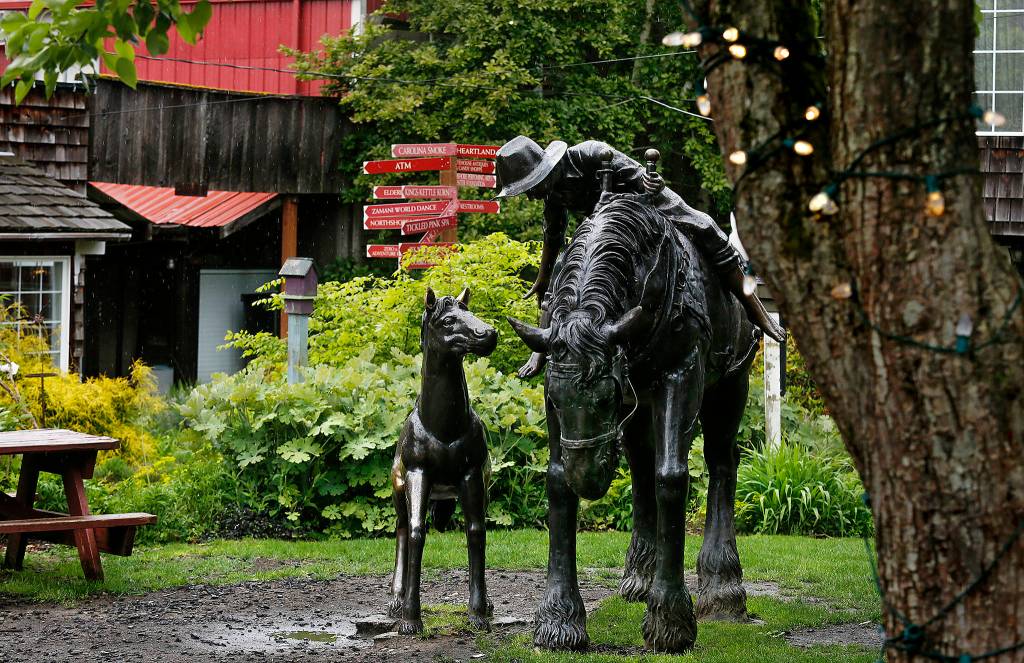 A whimsical sculpture of a western scene centers one of several cozy courtyards found between the shop buildings in Bothell&rsquo;s Country Village on Thursday. (Dan Bates / The Herald)
