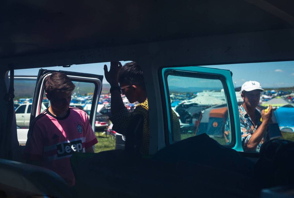 Bruno Wolf (left) talks with his friend Josef Stoeger while Sam Rudine applies sunscreen at their campsite before heading into the festival grounds during day three of the annual Sasquatch! Music Festival on Sunday, May 28, 2017 in George, Wa. (Daniella Beccaria / For the Herald )