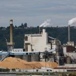 Piles of wood chips sit near the RockTenn paper mill in Tacoma, in this photo from June, 2016. Even as the Trump administration seeks to roll back Obama-era rules to curb greenhouse gas emissions at coal-fired power plants and leave the Paris climate agreement, Washington state is forging ahead with its own rules to cap carbon pollution from big industrial facilities. But the state faces legal challenges as it begins requiring large polluters such as RockTenn. (Ted S. Warren / Associated Press file photo)
