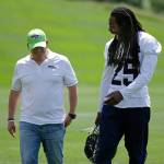 Seattle Seahawks cornerback Richard Sherman laughs Friday as he walks with general manager John Schneider following Friday&rsquo;s practice in Renton. (AP Photo/Ted S. Warren)