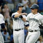 Seattle&rsquo;s Kyle Seager (right) is greeted by Robinson Cano (22) and Boog Powell after Seager&rsquo;s three-run home run in the fourth inning of the Mariners&rsquo; 12-3 win over Minnesota Tuesday in Seattle. (AP Photo/Elaine Thompson)