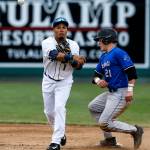 Aquasox infielder Joseph Rosa (left) throws to first base to complete a double play as Merchants runner Matt Thompson slides into second base during the Everett Cup exhibition game on June 13, 2017, at Everett Memorial Stadium. (Ian Terry / The Herald)