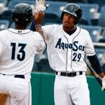 Aquasox center fielder Brayan Hernandez (right) high-fives teammate Greifer Andrade after scoring in the Everett Cup exhibition game on June 13, 2017, at Everett Memorial Stadium. (Ian Terry / The Herald)