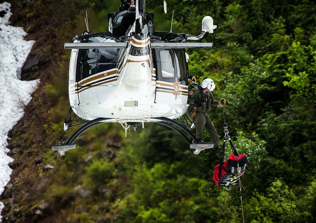 A mock victim is hoisted into a helicopter during Snohomish County Search and Rescue training at the Big Four Ice Caves on June 10. (Ian Terry / The Herald)