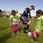 Everett Police Department recruit John Dorscher tries to keep a soccer ball away from Stephanie Garzon (left) and Ashley Gutierrez-Corona during the Casino Road Futbol Academy held at Walter E. Hall Park on Thursday in Everett. (Andy Bronson / The Herald)