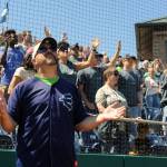 Wearing an AquaSox jersey and hat, New Life Church Pastor Jim Romack prays along with members of the church during a song played by the church&rsquo;s band at the One Day event held at Everett Memorial Stadium Ballfield on Sunday, June 11. (Doug Ramsay / For The Herald)