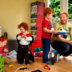 In their basement playroom Thursday morning, Alex Clawson, 32, communicates firmly and thoughtfully with his eldest son Willem, 4, while son Atley, 3 (left), plays with 20-month-old daughter Seirsha, who is wearing a Spider-Man cape. Clawson&rsquo;s wife and the children&rsquo;s mother, Amy Clawson, 33, as well as newborn daughter Elayda, died May 21 after Amy suffered heart failure. (Dan Bates / The Herald)
