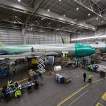 A worker uses a lift to get onto the wing of a KC-46 Pegasus aerial-refueling tanker at the Boeing Everett Modification Center last month. (Andy Bronson / The Herald)