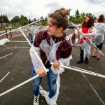 Kadie Harrett (center) is not just caught up in her work, but might have even torn her space suit as she and classmates attempt construction of a Mars habitat Monday outside Haller Middle School in Arlington, where sixth-graders spent the day building a mock Mars colony. (Dan Bates / The Herald)