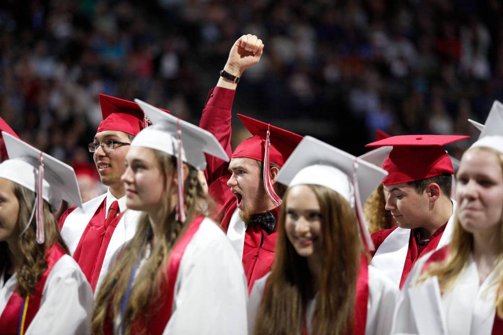 A Snohomish graduate cheers after the school alma mater song is played at the end of the graduation ceremony at Xfinity Arena on Monday in Everett. (Andy Bronson / The Herald)