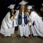 Glacier Peak High School&rsquo;s Rumie Lee (left) and Sara Major (right) pretend to knock over Madeline Mahler, who is on crutches, as they take a picture together before their graduation ceremony at Xfinity Arena on Monday in Everett. (Andy Bronson / The Herald)