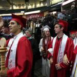 Snohomish High class president Josue Barajas (left) practices a wave before he leads his classmates to the graduation ceremony at Xfinity Arena on Monday in Everett. (Andy Bronson / The Herald)