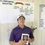 Alvin Kwak poses next to the leader board after winning the U.S. Junior Open qualifier last week at Classic Golf Club in Spanaway. (Washington State Golf Association)