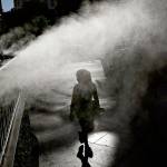 A girl walks through a mister during the start last week of a heat wave in Las Vegas. (AP Photo/John Locher)