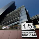 A sign is displayed below Seattle City Hall and the Columbia Center building (left) in 2014 after the Seattle City Council passed a $15 minimum wage measure. (AP Photo/Ted S. Warren, File)