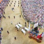 The crowd looks on as an oxen cart pulls the Palio banner through Siena&rsquo;s main square. (Rick Steves&rsquo; Europe)