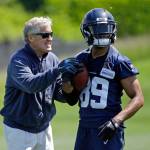 Seahawks head coach Pete Carroll (left) playfully grabs at the hands of wide receiver Doug Baldwin during practice on June 2, 2017, in Renton. (AP Photo/Ted S. Warren)