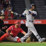 The Mariners&rsquo; Robinson Cano (right) hits a three-run home run as Angels catcher Juan Graterol watches along with home plate umpire Sean Barber during the fifth inning of a game June 30, 2017, in Anaheim, Calif. (AP Photo/Mark J. Terrill)