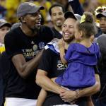 Golden State Warriors Kevin Durant (left) and Stephen Curry celebrate their NBA championship Monday night in Oakland, California. (Marcio Jose Sanchez / Associated Press)