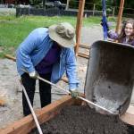 Kristen Hunt spreads fill as Rowan Abbott empties her wheelbarrow in a newly constructed garden bed Saturday afternoon at Eagle Ridge Park in Lake Stevens. (Kevin Clark / The Herald)