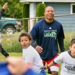 Tyler Lockett with campers track a thrown football during drills Saturday morning at Edmonds-Woodway High School. (Kevin Clark / The Herald)