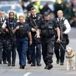 Armed British police officers walk with a detection dog within a cordoned off area after an attack in the London Bridge area of London, Sunday, June 4, 2017. Police specialists collected evidence in the heart of London after a series of attacks described as terrorism killed several people and injured more than 40 others. (AP Photo/Matt Dunham)