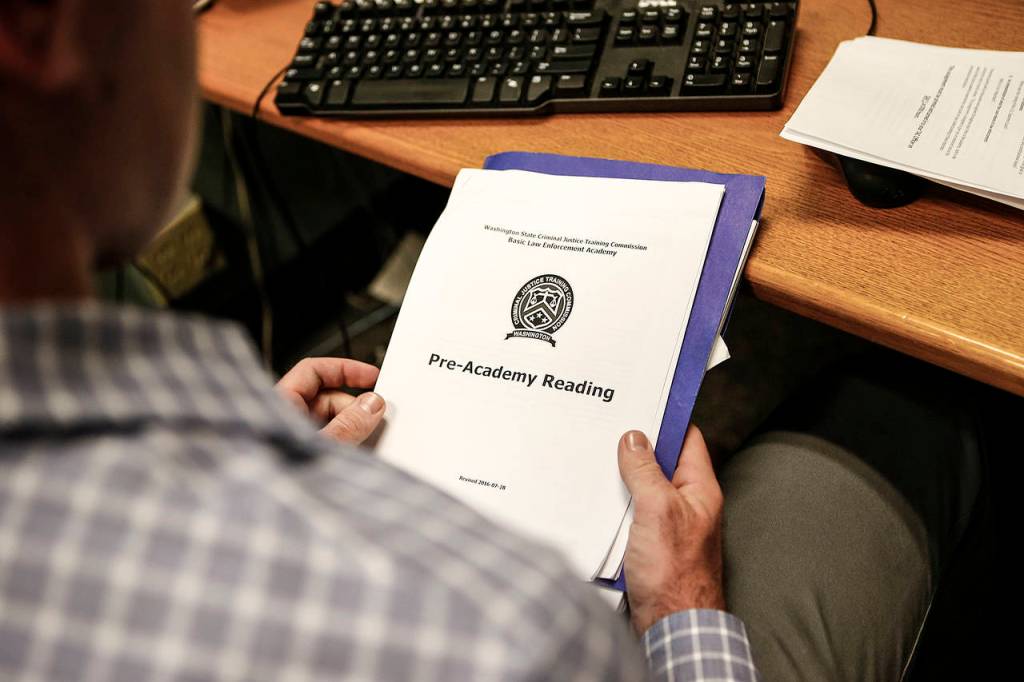 New Everett Police Department recruit Brett Janke goes through a reading packet that covers the basics of police academy. (Ian Terry / The Herald)