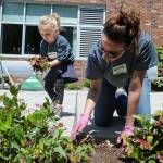 New Life Church member Katrina Schmidt, of Bothell, along with her daughter, Aeralynn, 4, pull weeds from a planting bed in front of the Everett Public Schools Community Resource Center during the church&rsquo;s One Day event on Sunday. (Doug Ramsay / for The Herald)
