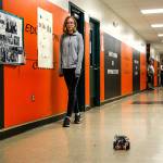 Granite Falls Middle School eighth-grader Michele Greenlee follows an EV3 robot that she programmed to travel out of the classroom and down the hall while passing through two doors and arriving at principal Dave Bianchini&rsquo;s office. Coincidentally, Bianchini (blue shirt background) is watching, along with teachers Diana Haynes and Kirk Parker. (Dan Bates / The Herald)