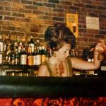 Sue Brauch, now 76, tends bar decades ago at The Flame, at the time a popular Kirkland restaurant overlooking Lake Washington. (Courtesy Sue Brauch)
