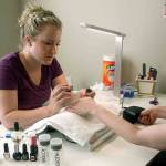 The author gives her sister a gel manicure at her do-it-yourself nail salon inside her Everett home. (Vanessa McVay / The Herald)