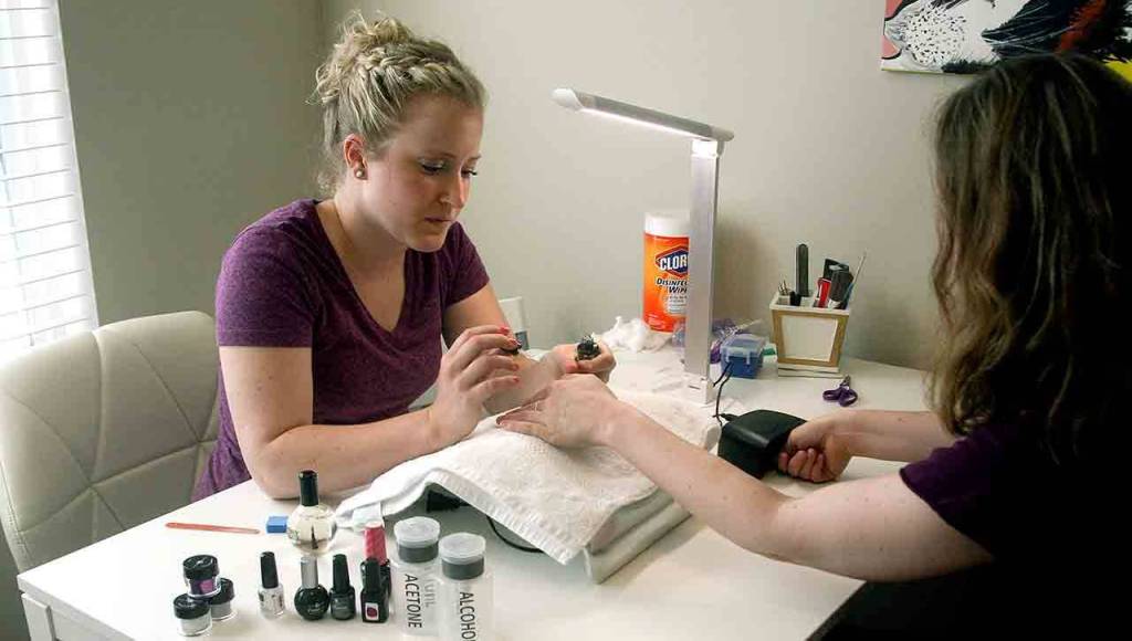 The author gives her sister a gel manicure at her do-it-yourself nail salon inside her Everett home. (Vanessa McVay / The Herald)