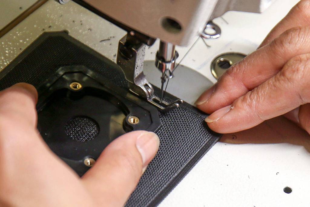 A seamstress sews new helmet padding at RAM Technologies in Mukilteo on June 7. (Kevin Clark / The Herald)