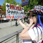 Cathy Camper, of Tacoma, wears a stars-and-stripes cowboy hat as she protests against Islamic law and reacts to counter-protesters across the street at a rally Saturday, June 10, in Seattle. (AP Photo/Ted S. Warren)
